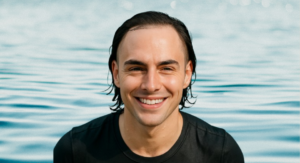 A man emerging from a swimming pool, hair wet but system perfectly intact.